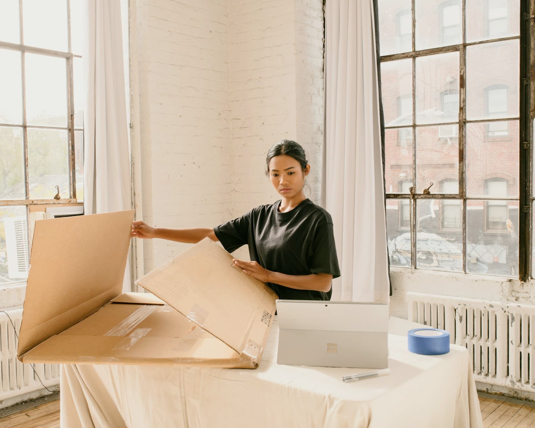 Small business operator packing customer orders beside a laptop