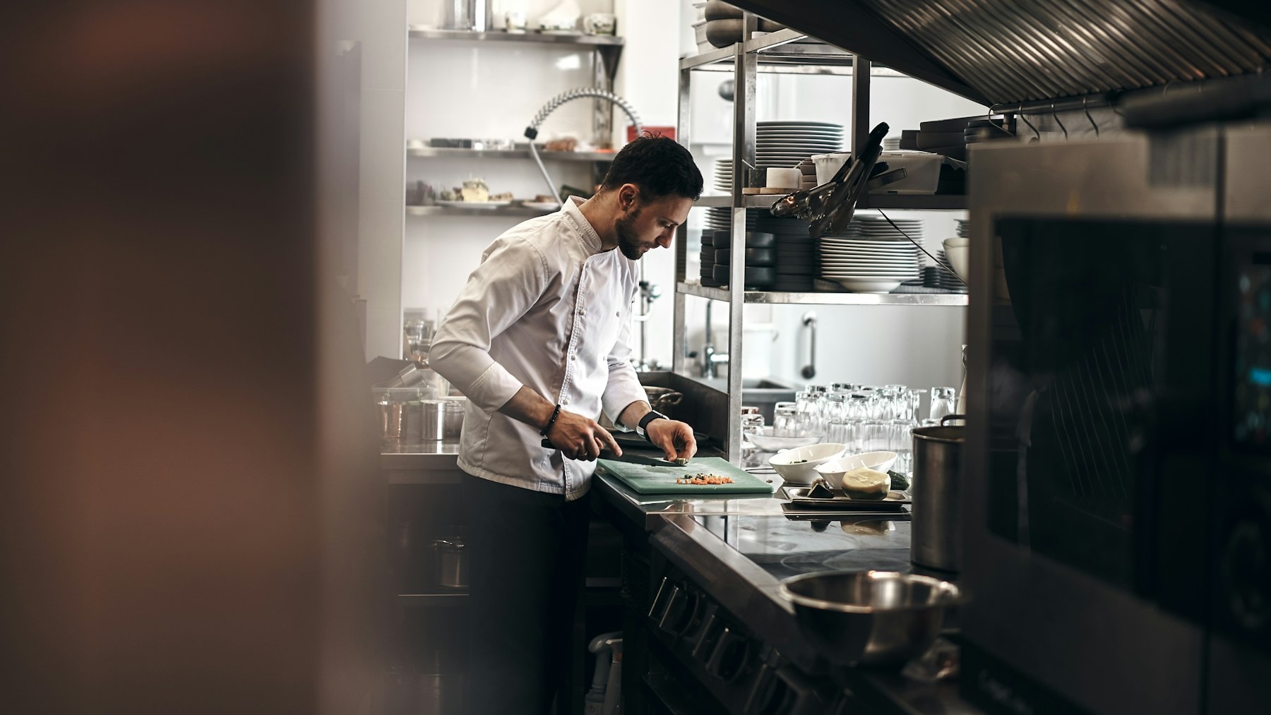 Chef preparing ingredients in a working restaurant kitchen
